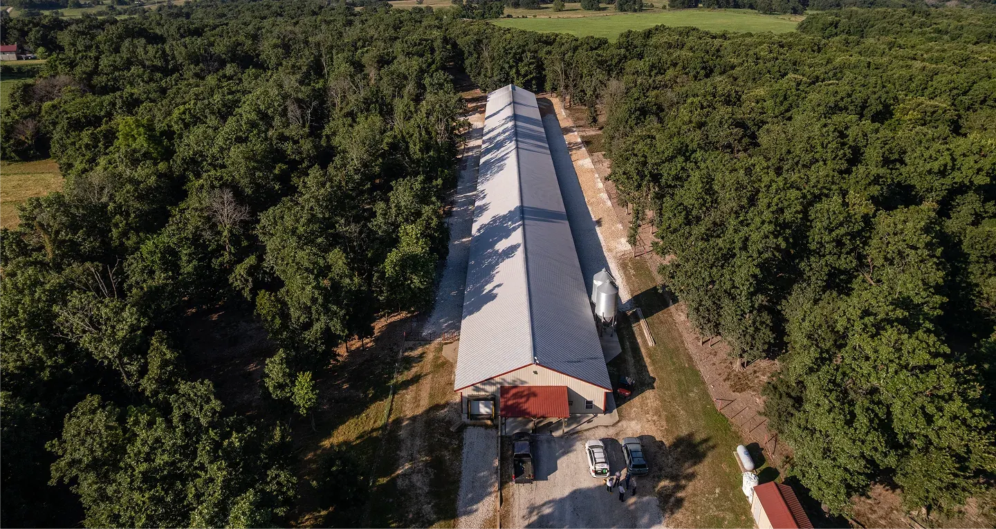 Aerial view of a Vital Farms barn, surrounded by pasture and trees.