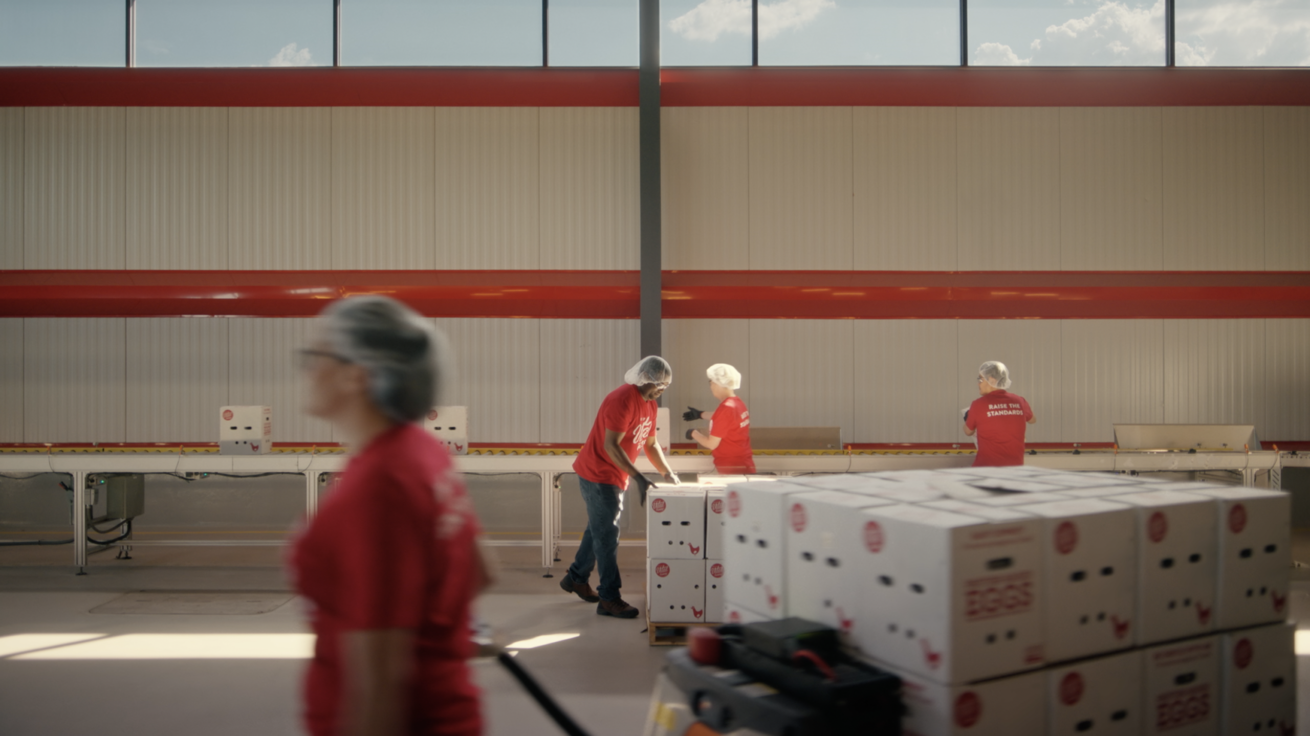 Crewmembers stack and carry egg boxes